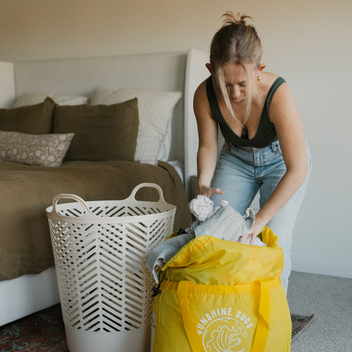 A woman loading laundry into a yellow bag