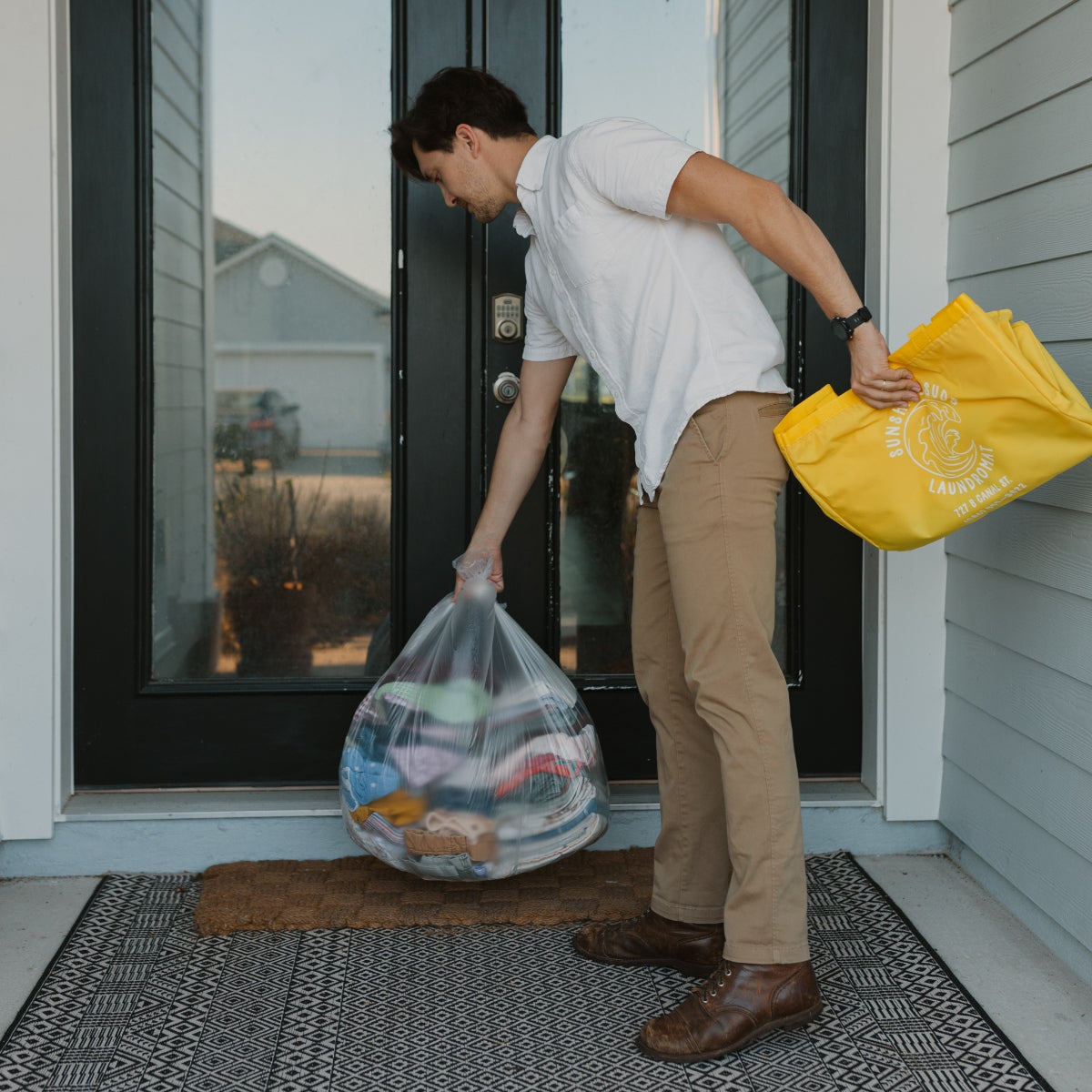 A man returning a customers laundry to their door